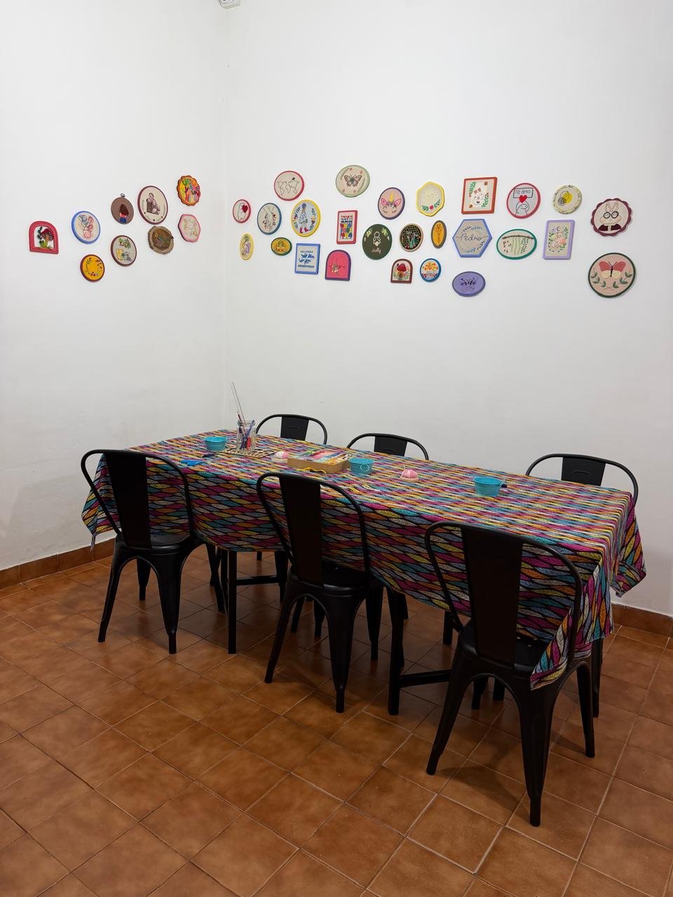 Espacio del taller de bordado con bastidores y proyectos terminados
